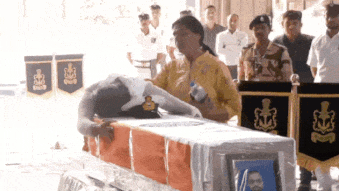 Watch: Wife of slain Navy officer clings to coffin in tearful farewell